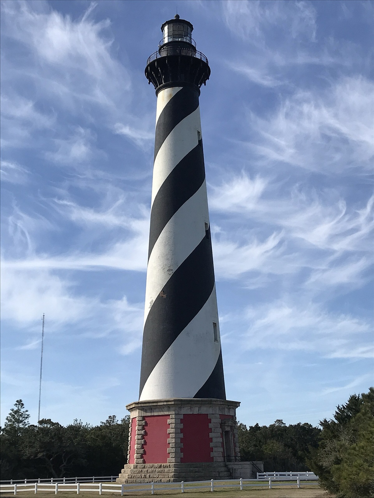 The black-and-white spiral-striped Cape Hatteras Lighthouse rising above the dunes of the North Carolina Outer Banks.